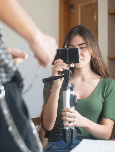 A creator looking through a phone camera while filming